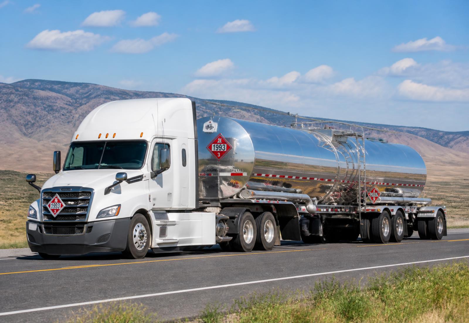 Tanker truck hauling placarded hazardous materials on a highway