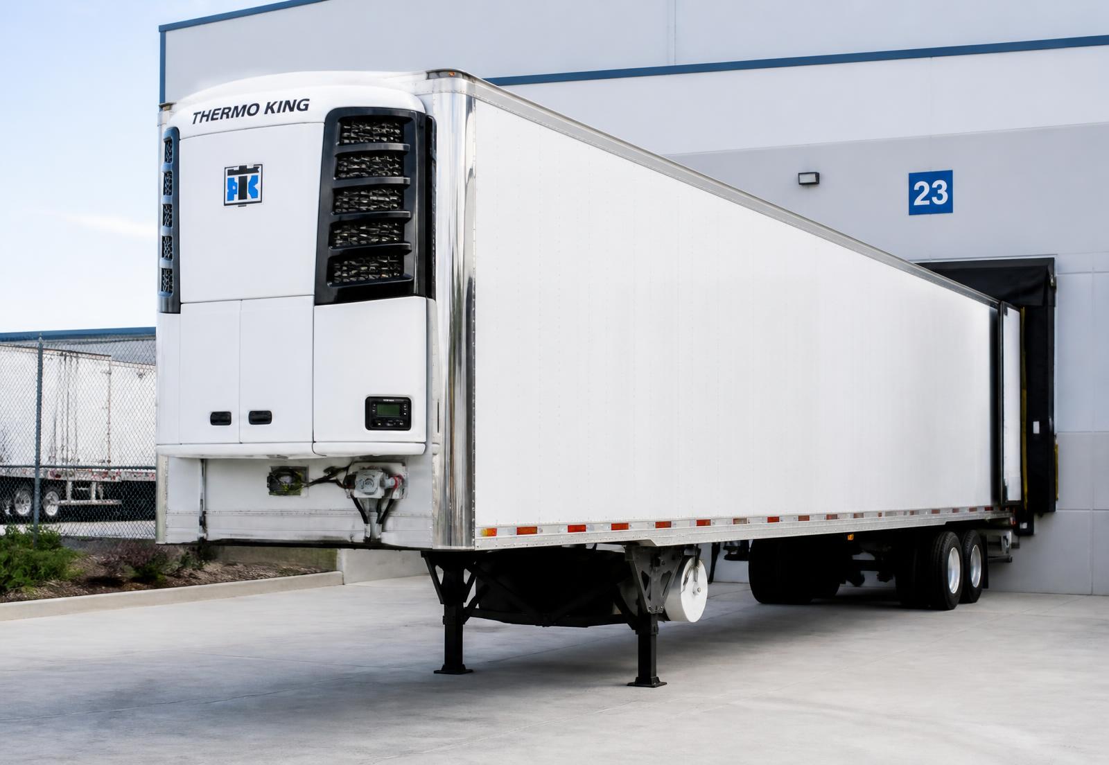 Refrigerated trailer being loaded with fresh produce at a cold storage dock